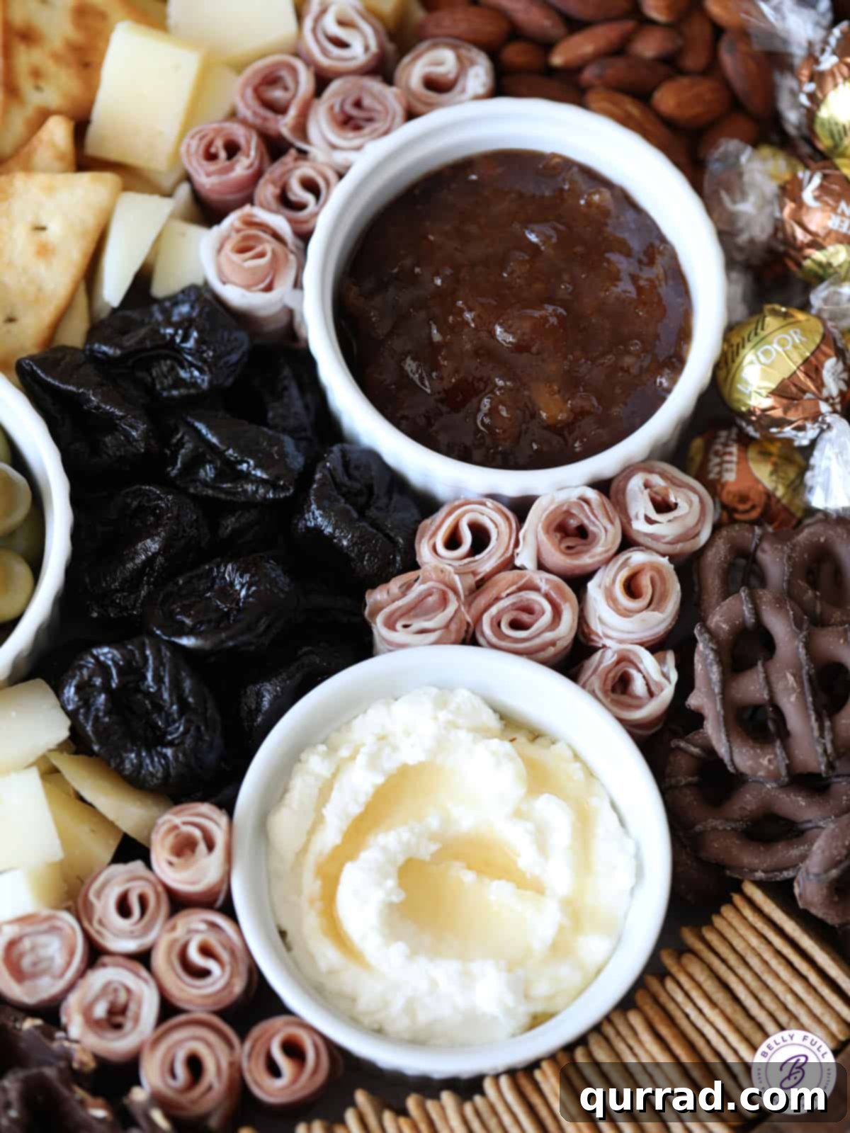 Close-up view of small serving bowls on a charcuterie board, featuring a rich fig jam and creamy homemade ricotta cheese