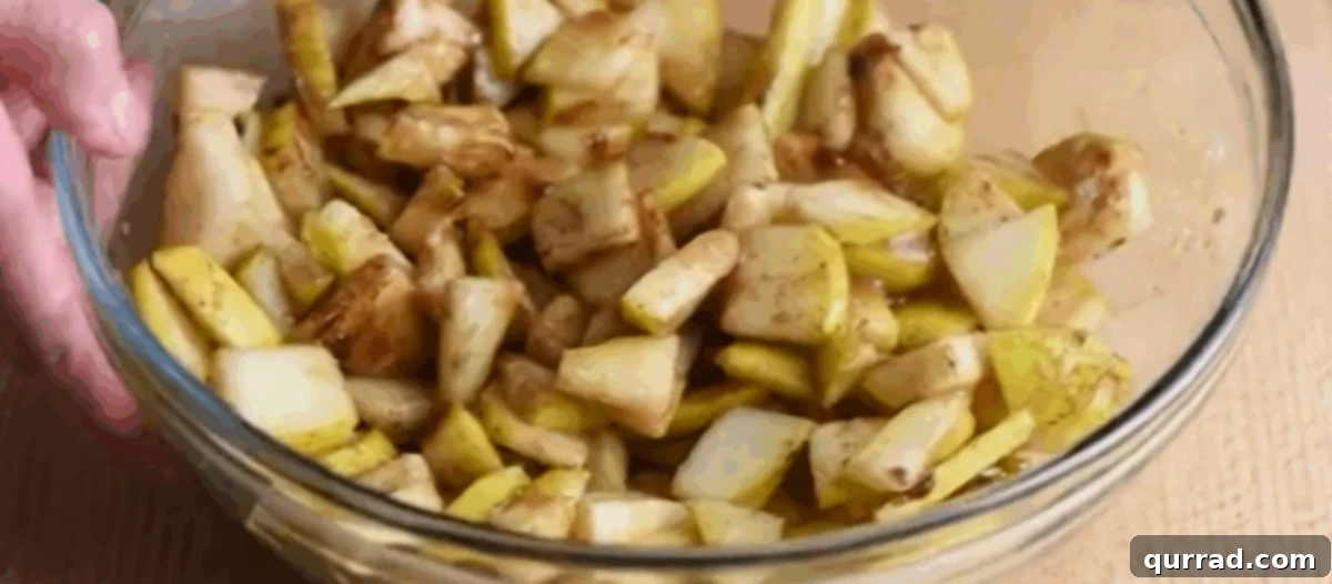 A glass bowl filled with sliced pears, brown sugar, lemon juice, cornstarch, vanilla, cinnamon, and salt for the crisp filling.