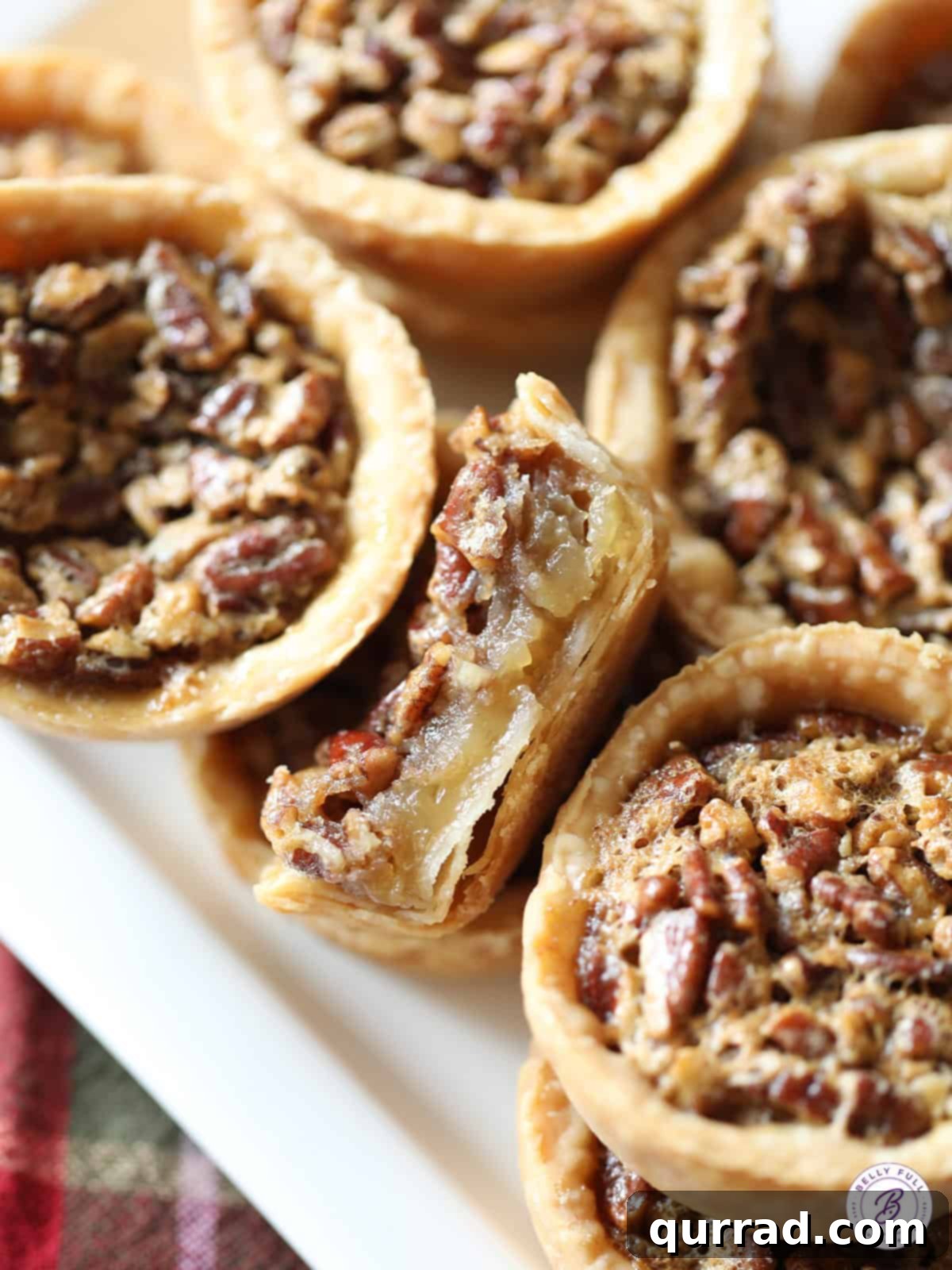 Pecan Pie Bites 4 A close-up view of a mini pecan pie, sliced in half to reveal its luscious, gooey filling and crunchy pecans.
