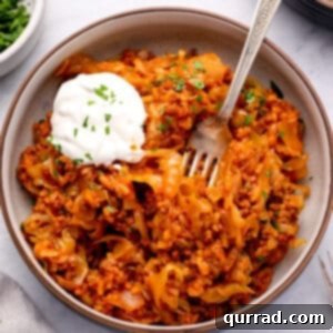 unstuffed cabbage rolls in bowl with sour cream and fork