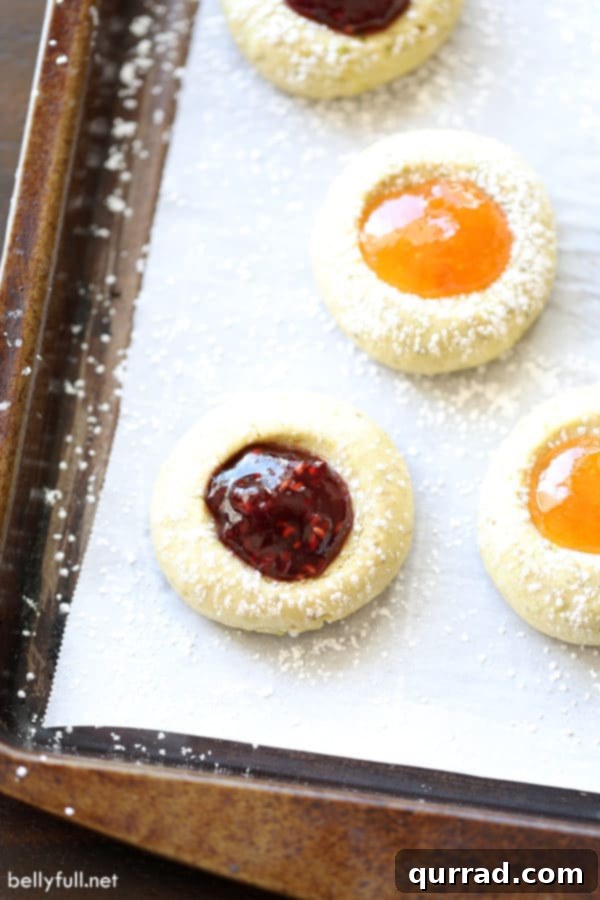 These Thumbprint Cookies are buttery shortbread, filled with your favorite jam and topped with powdered sugar. Perfect for the holidays or anytime! overhead Thumbprint Cookies filled with raspberry jam