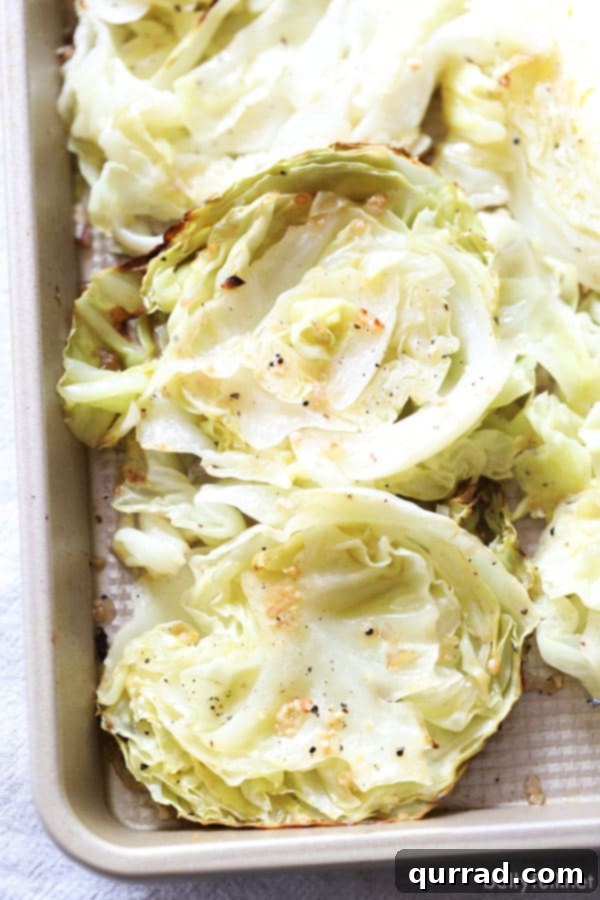 Perfectly Roasted Cabbage Steaks with Olive Oil, Shallot, Garlic, and Crispy Bacon Golden brown roasted cabbage steaks basted with olive oil, shallot, garlic, salt, and pepper in a roasting pan, garnished with crispy bacon.