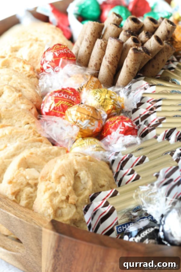A bountiful Charcuterie Board filled with an array of festive cookies, smooth chocolate truffles, crisp Pirouline wafers, and refreshing peppermint bark, ready for holiday enjoyment