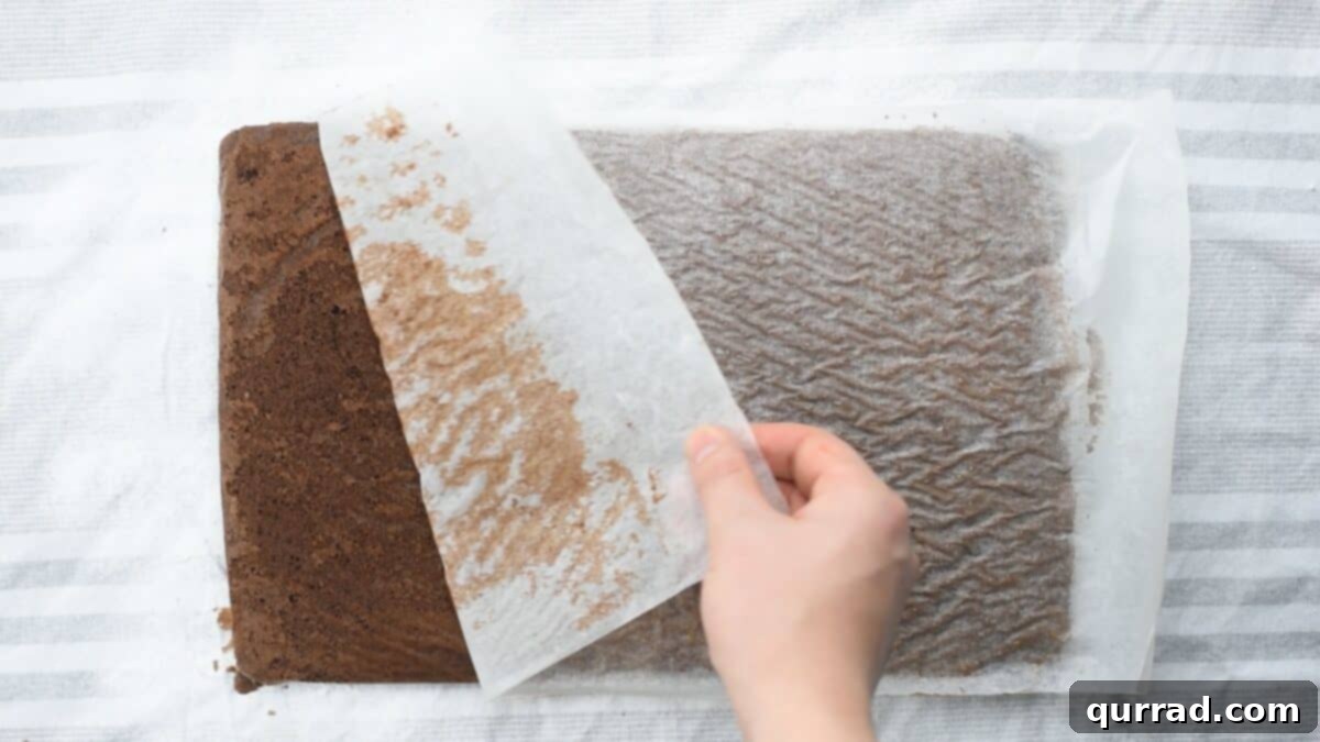 Decadent Chocolate Log 8 Removing the parchment paper from the cake.