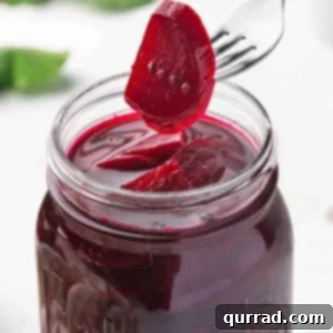 Pickled beets on a fork held over a glass jar