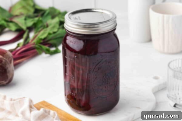 Tall glass jar filled with pickled beets, ready for the refrigerator