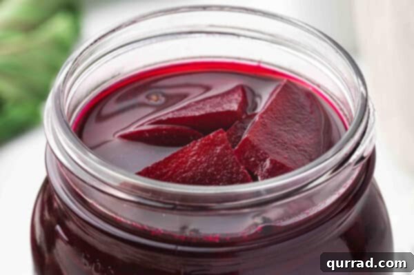 Close-up of sliced pickled beets at the top of a jar, ready to serve