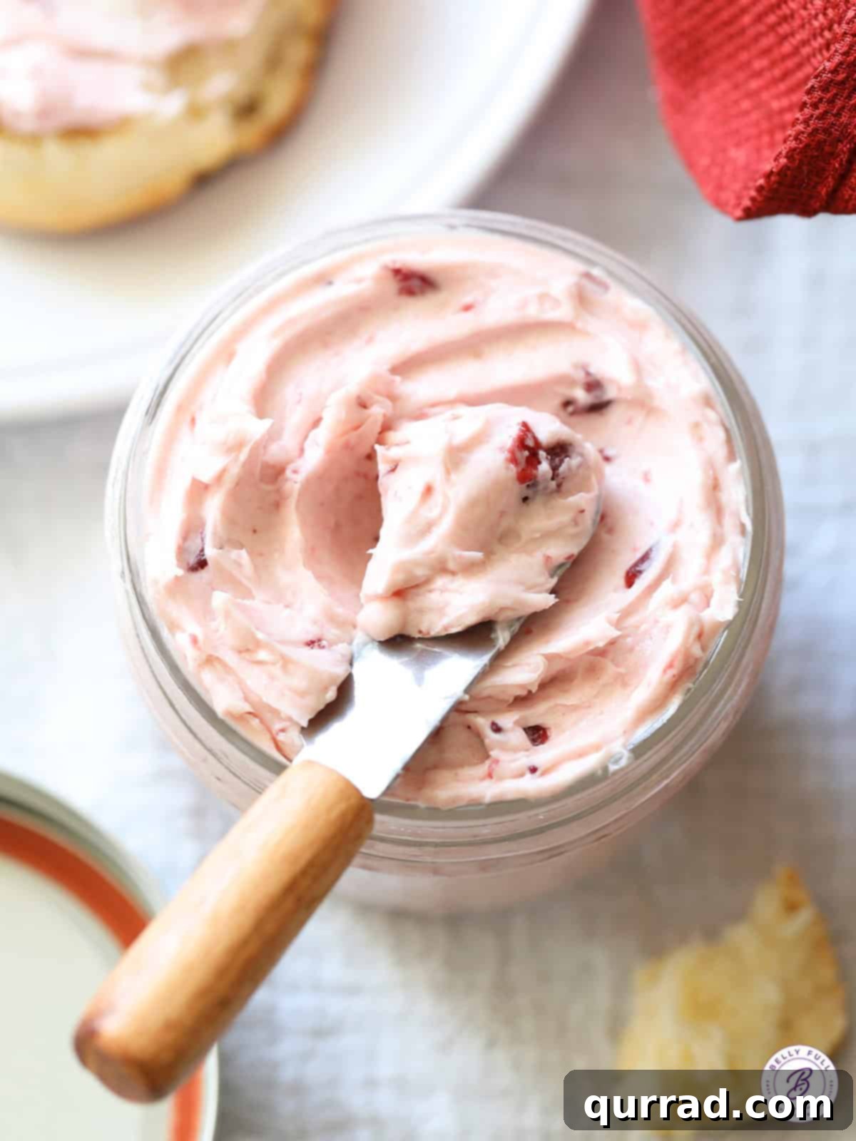 Sweet & Tangy Cranberry Honey Butter 4 A small knife with a scoop of cranberry honey butter on it, showcasing the smooth, creamy texture
