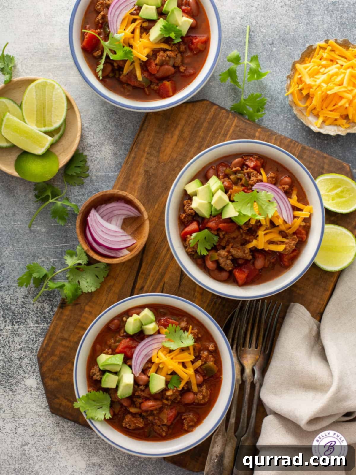 3 bowls of chili with garnishes