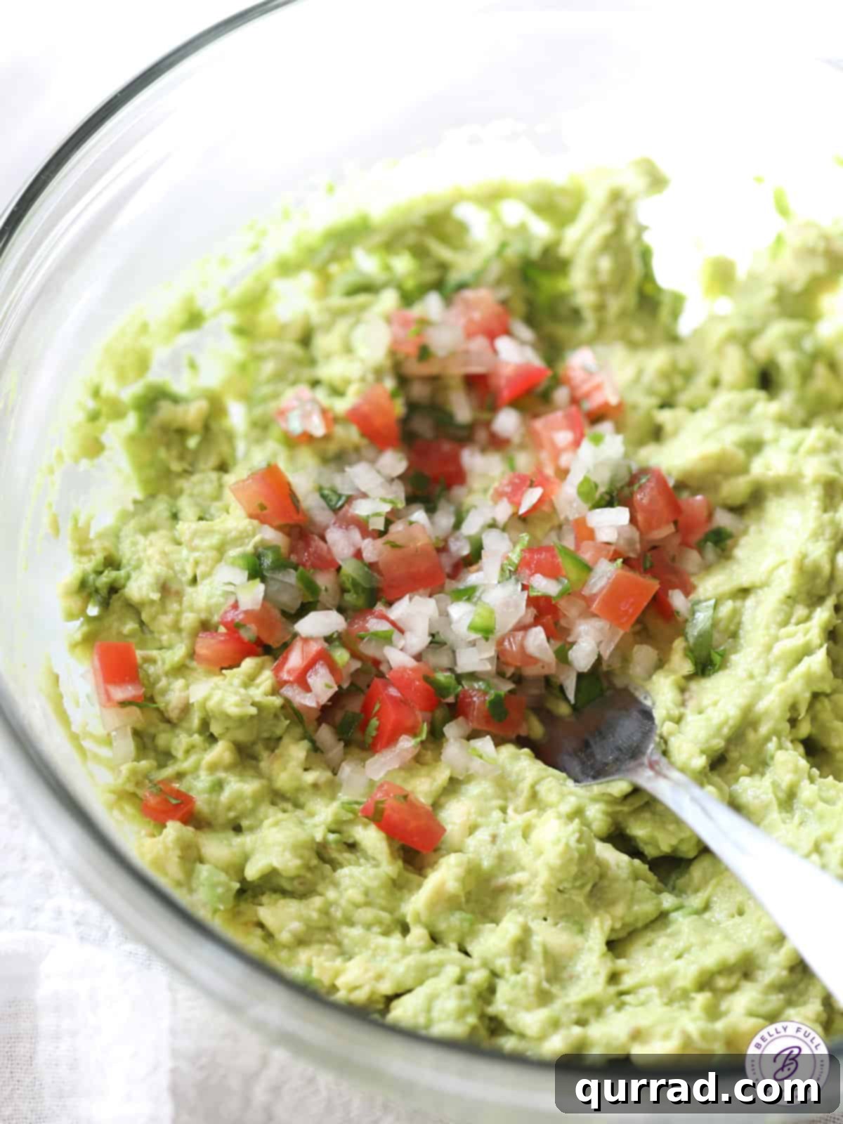 A bowl of freshly made guacamole with pico de gallo mixed in, ready for serving.