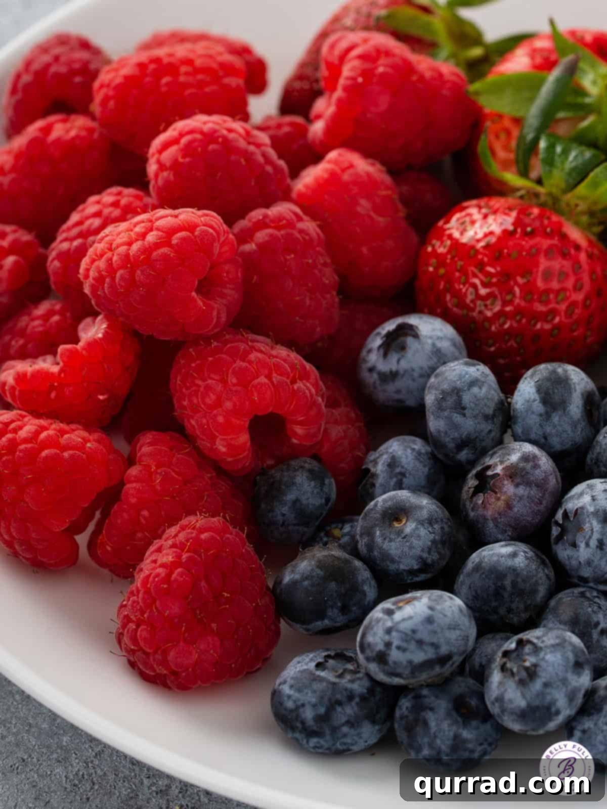 Nutty Brown Butter Berry Muffins 3 fresh raspberries, blueberries, and strawberries on plate