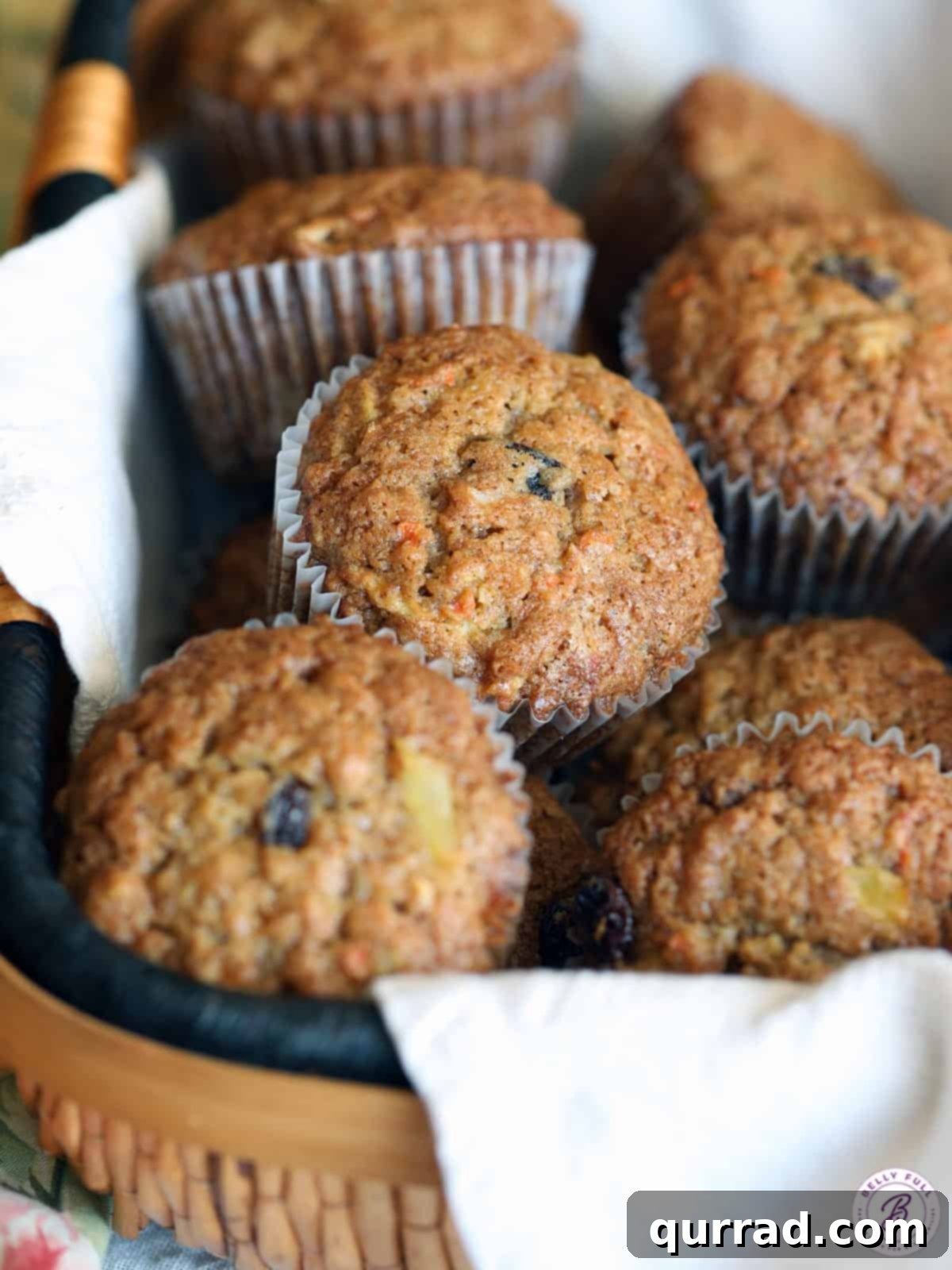 A charming basket overflowing with freshly baked Morning Glory Muffins, ready to be enjoyed.