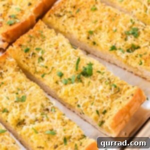 row of garlic bread slices on baking sheet