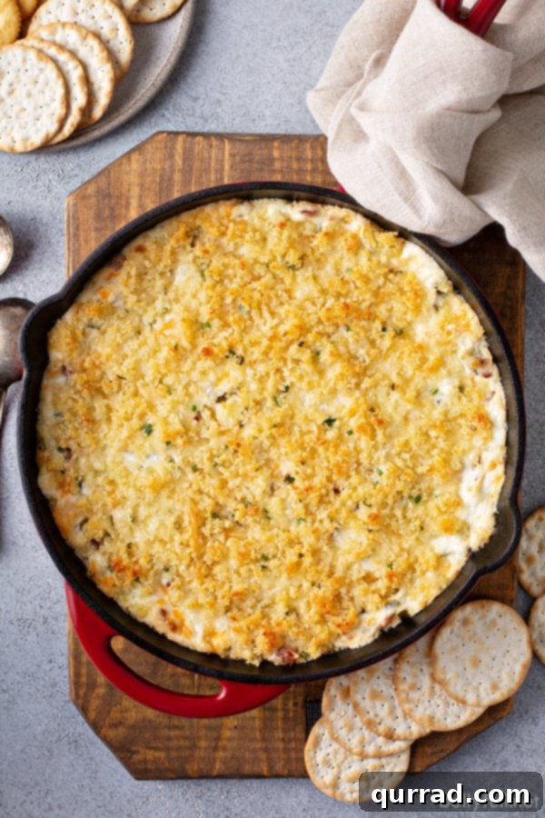 Loaded Cheesy Jalapeno Dip 4 Overhead shot of a bubbling Jalapeño Popper Dip in a cast iron skillet, ready to serve.