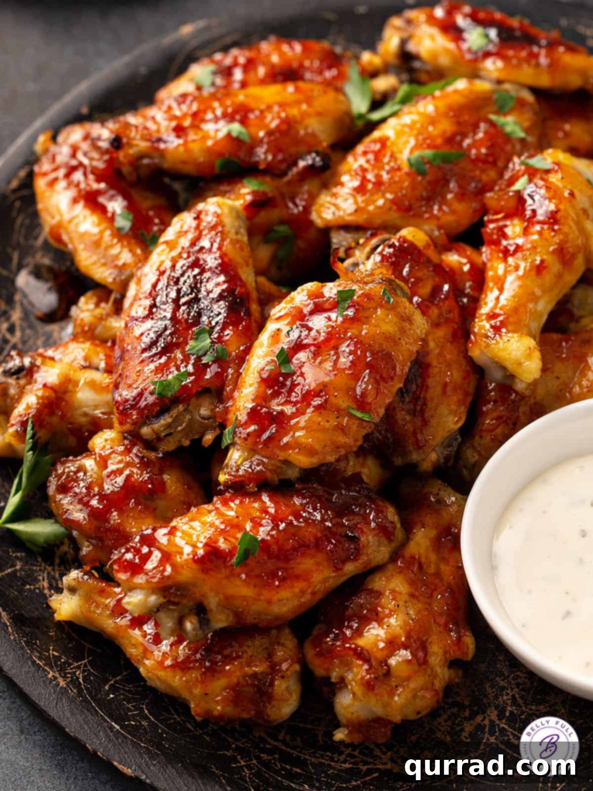 Overhead shot of a platter piled high with golden-brown baked chicken wings, glistening with Caribbean pineapple glaze