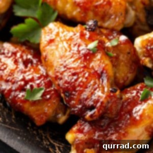 Close-up of golden-brown pineapple-basted baked chicken wings, glistening with glaze