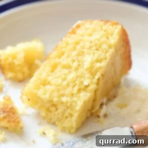 Golden Hearth Cornbread 3 A golden-brown slice of cornbread on a plate, ready to be enjoyed.