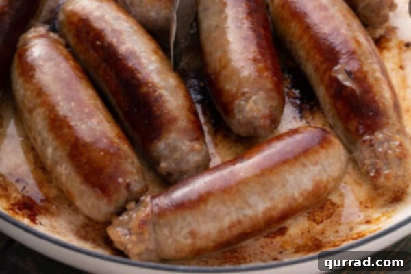 Sizzling Sausages and Creamy Mash 5 Golden-fried sausage links resting in a skillet, having been thoroughly cooked and browned.