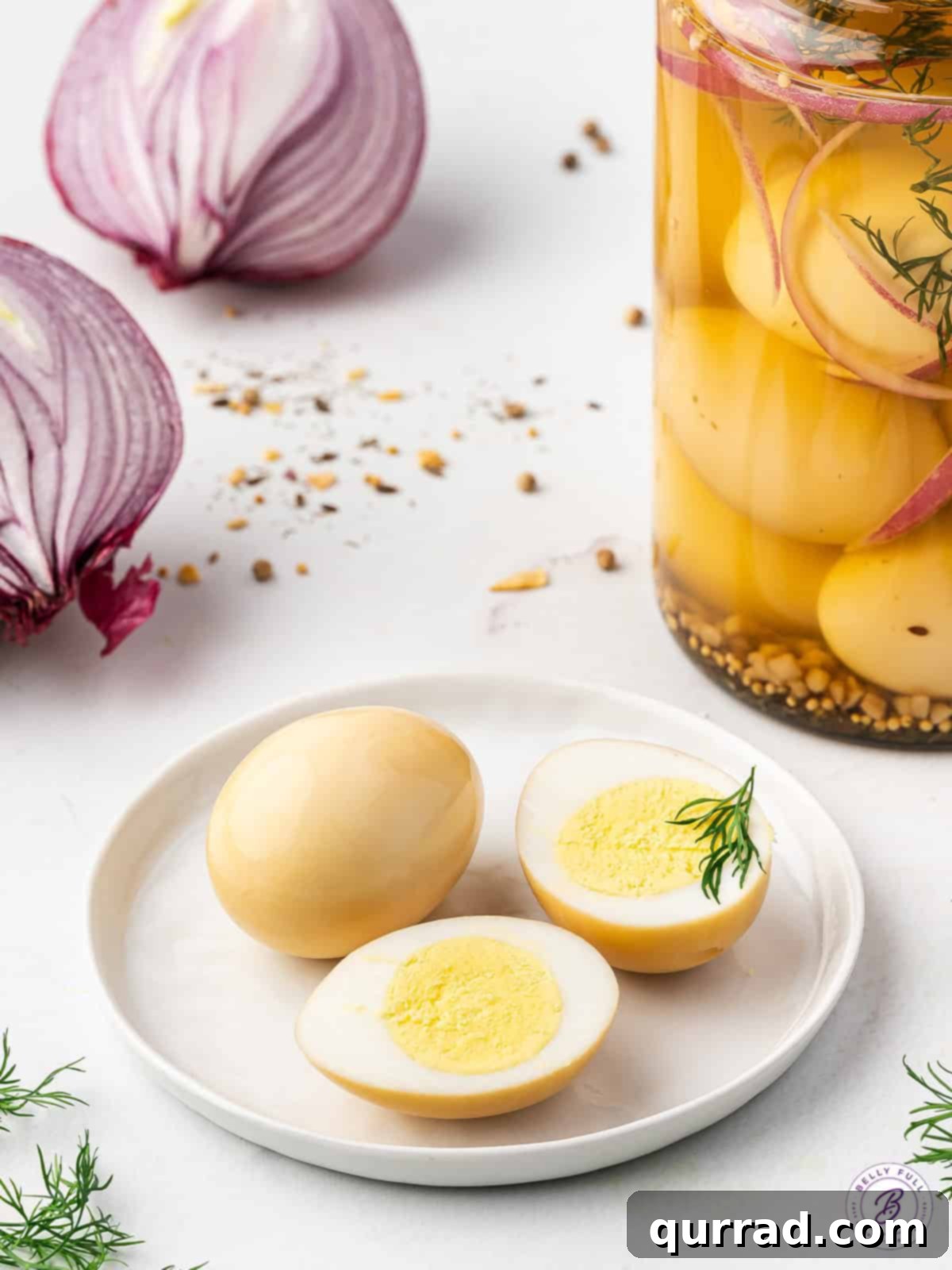 Vinegar-Kissed Eggs 11 Pickled eggs sliced in half, revealing their vibrant interior, arranged artfully on a white plate.
