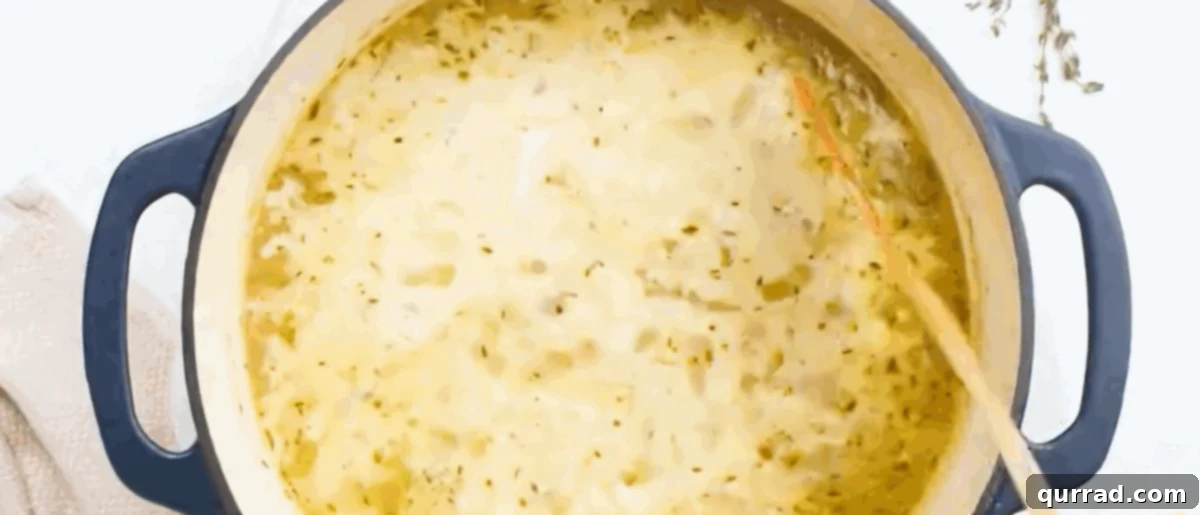 Creamy Golden Corn Chowder 9 Stirring heavy cream into the corn chowder in the pot.