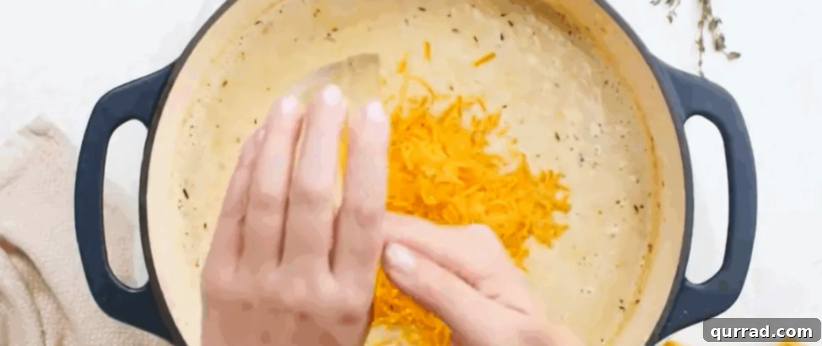 Creamy Golden Corn Chowder 10 Adding grated cheddar cheese to the blended corn chowder and stirring.
