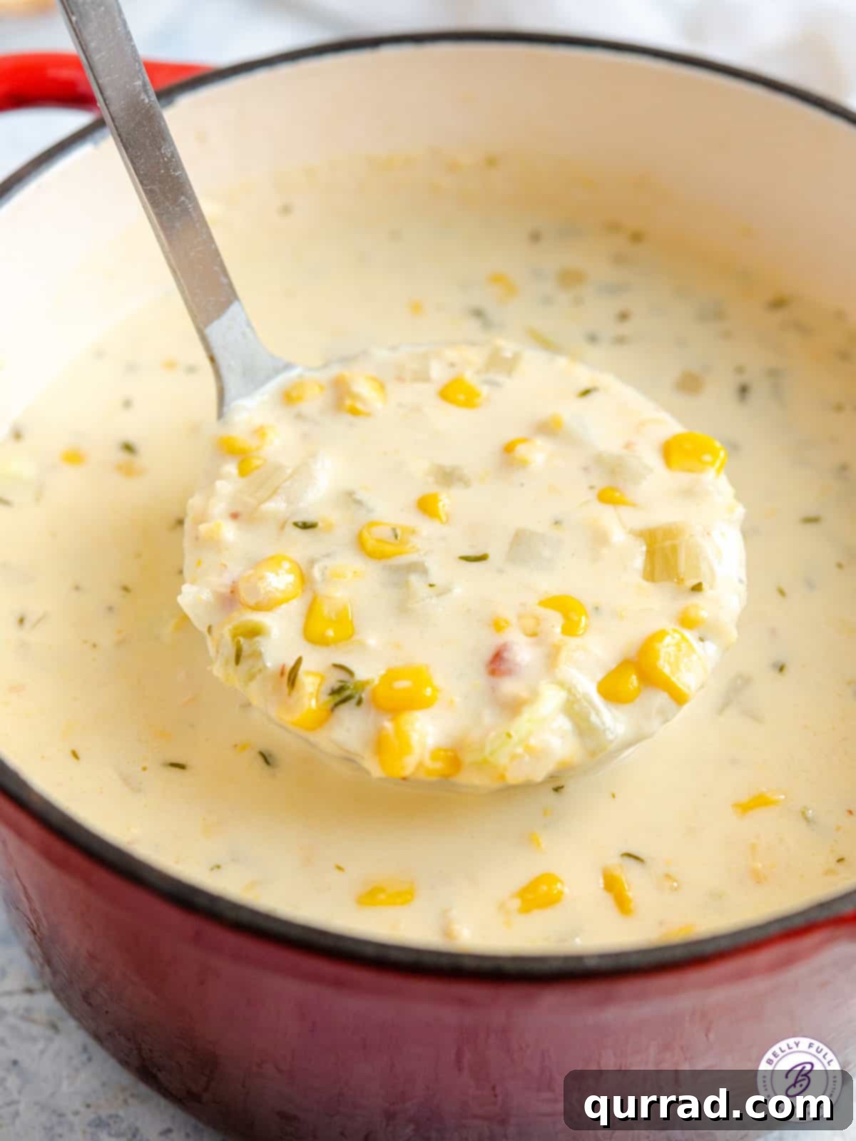 Creamy Golden Corn Chowder 12 A ladle scooping rich, creamy corn chowder from a pot.