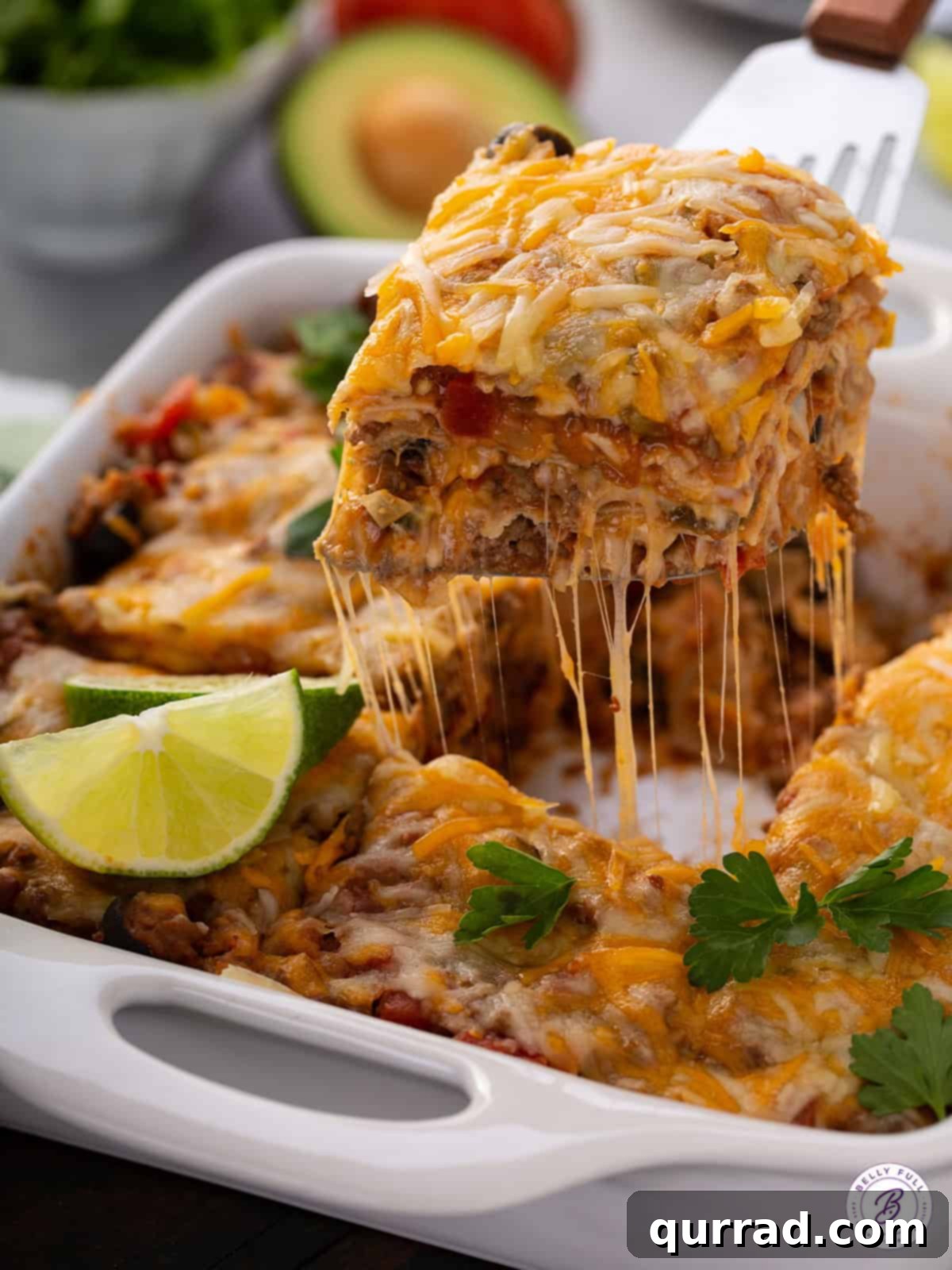 portion of Mexican Lasagna being lifted from casserole dish with a serving spatula