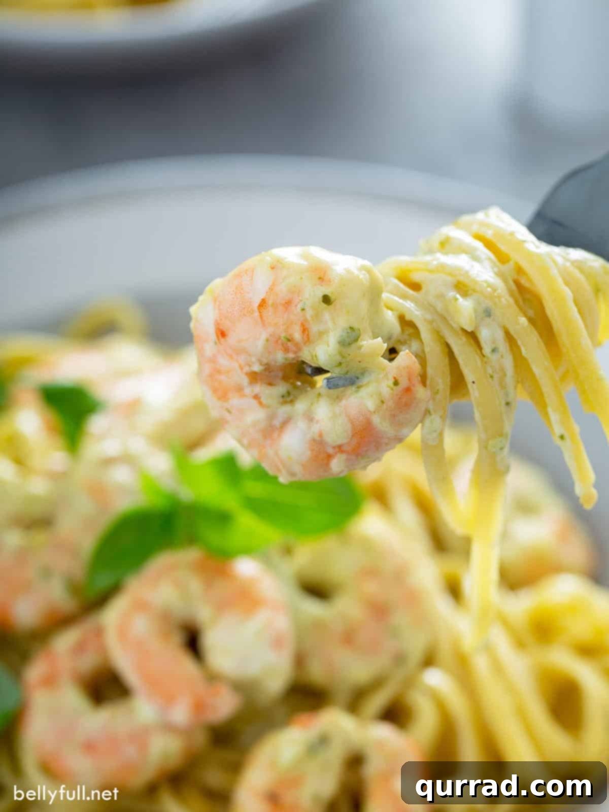 Zesty Shrimp Pesto Pasta 2 Close up cooked shrimp and pesto pasta on fork, ready to be enjoyed.