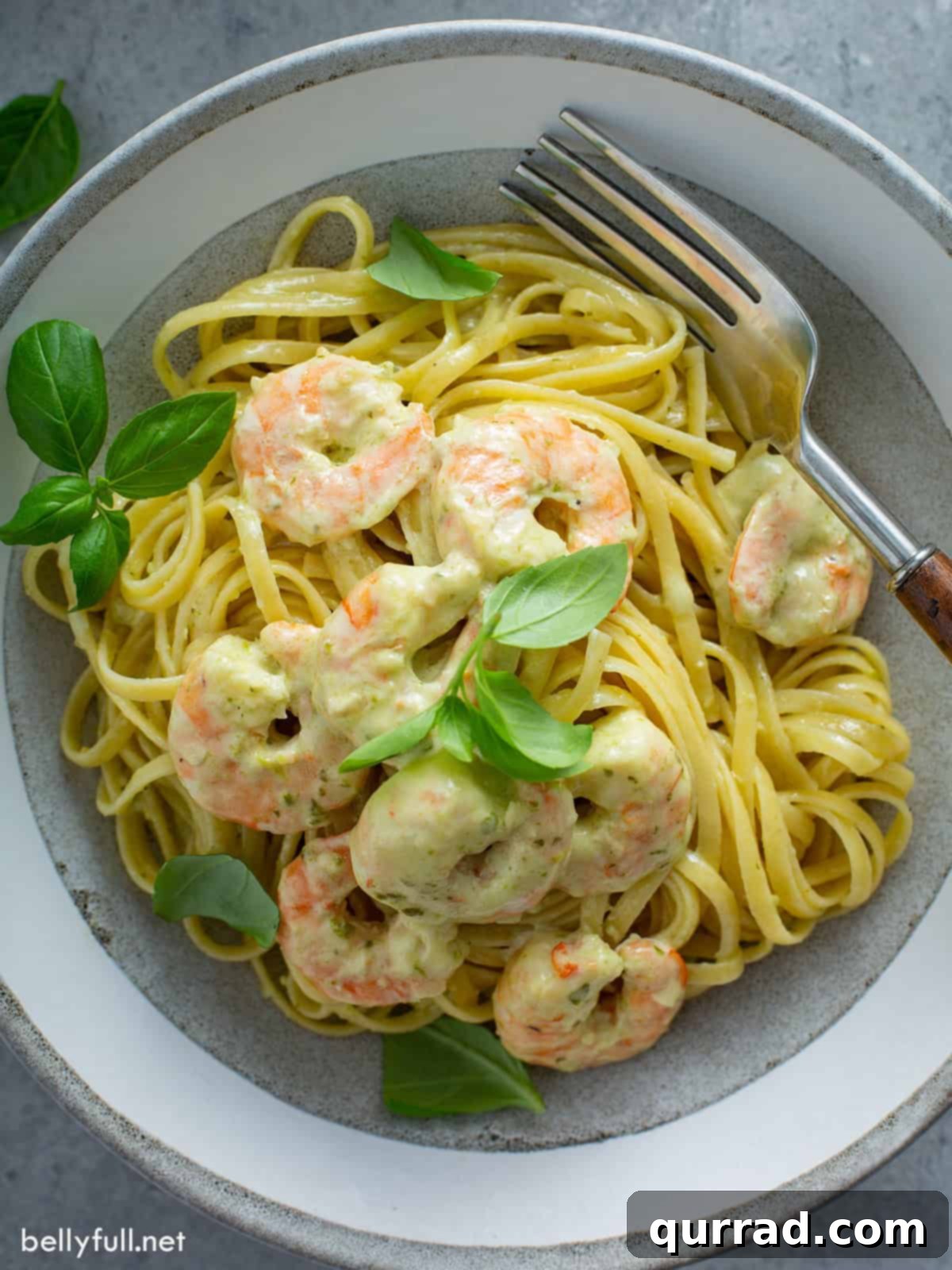Zesty Shrimp Pesto Pasta 9 Overhead shot of creamy pesto shrimp pasta in a bowl with fresh basil garnish.