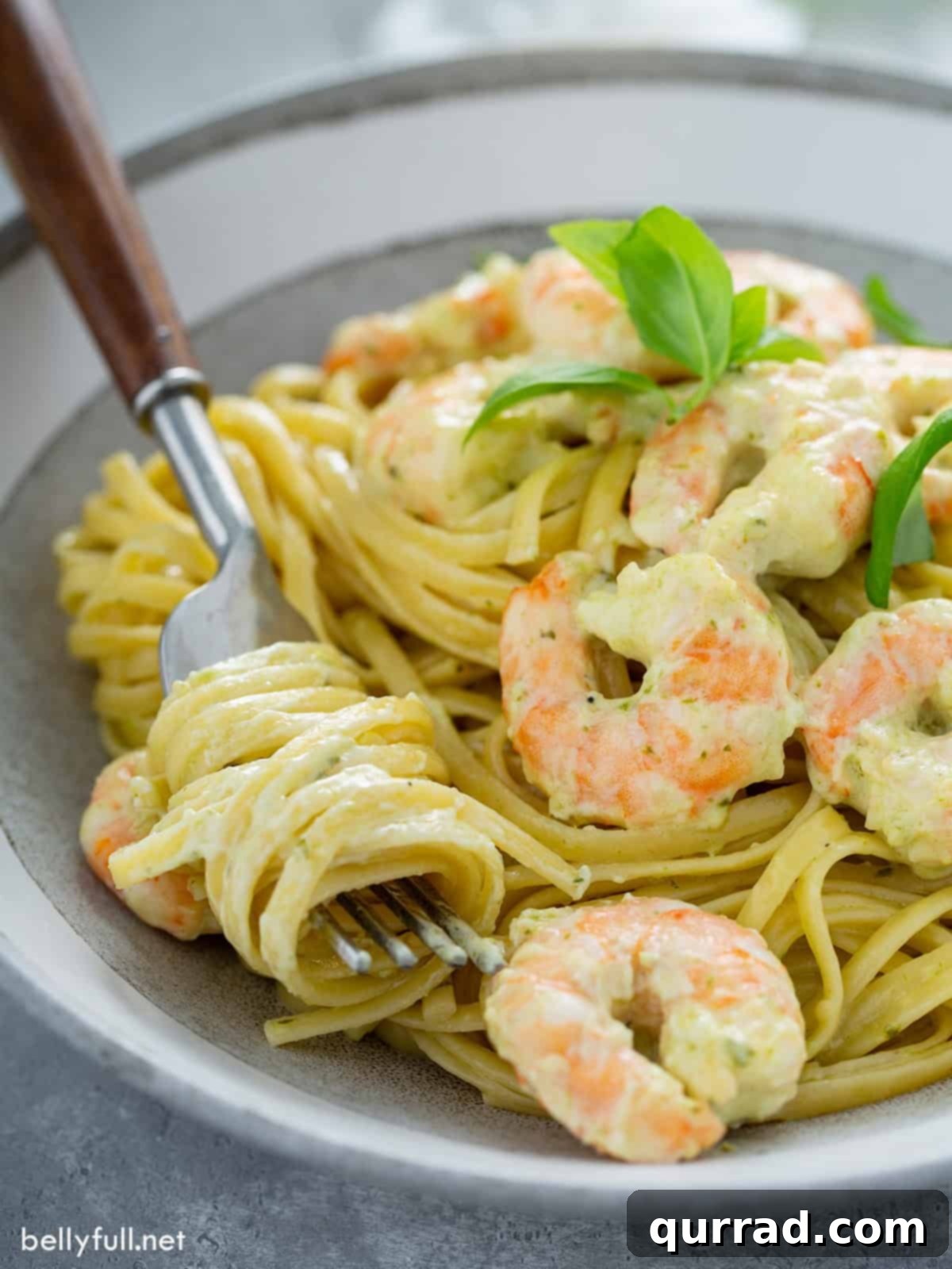 Zesty Shrimp Pesto Pasta 10 Close up creamy pesto pasta twirled around a fork, showing the rich sauce and tender shrimp.