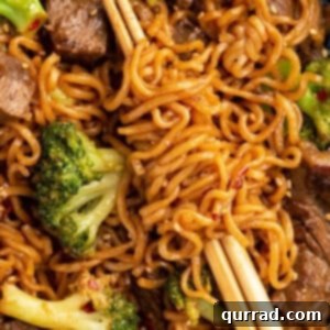 Close up picture of homemade beef and broccoli ramen stir fry swirled around chopsticks