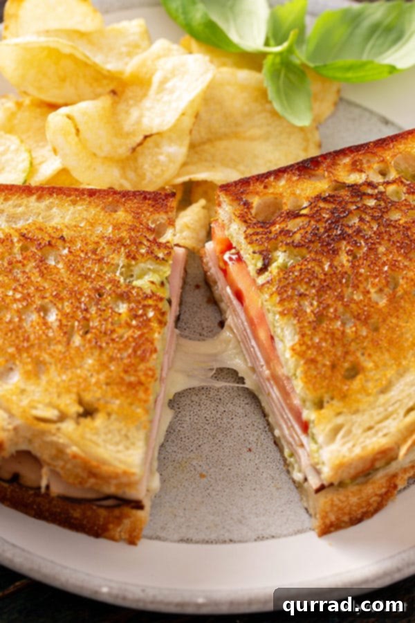 Elevate Your Grilled Cheese Game 5 Pesto grilled cheese sandwich, perfectly cut in half, on a plate ready to serve