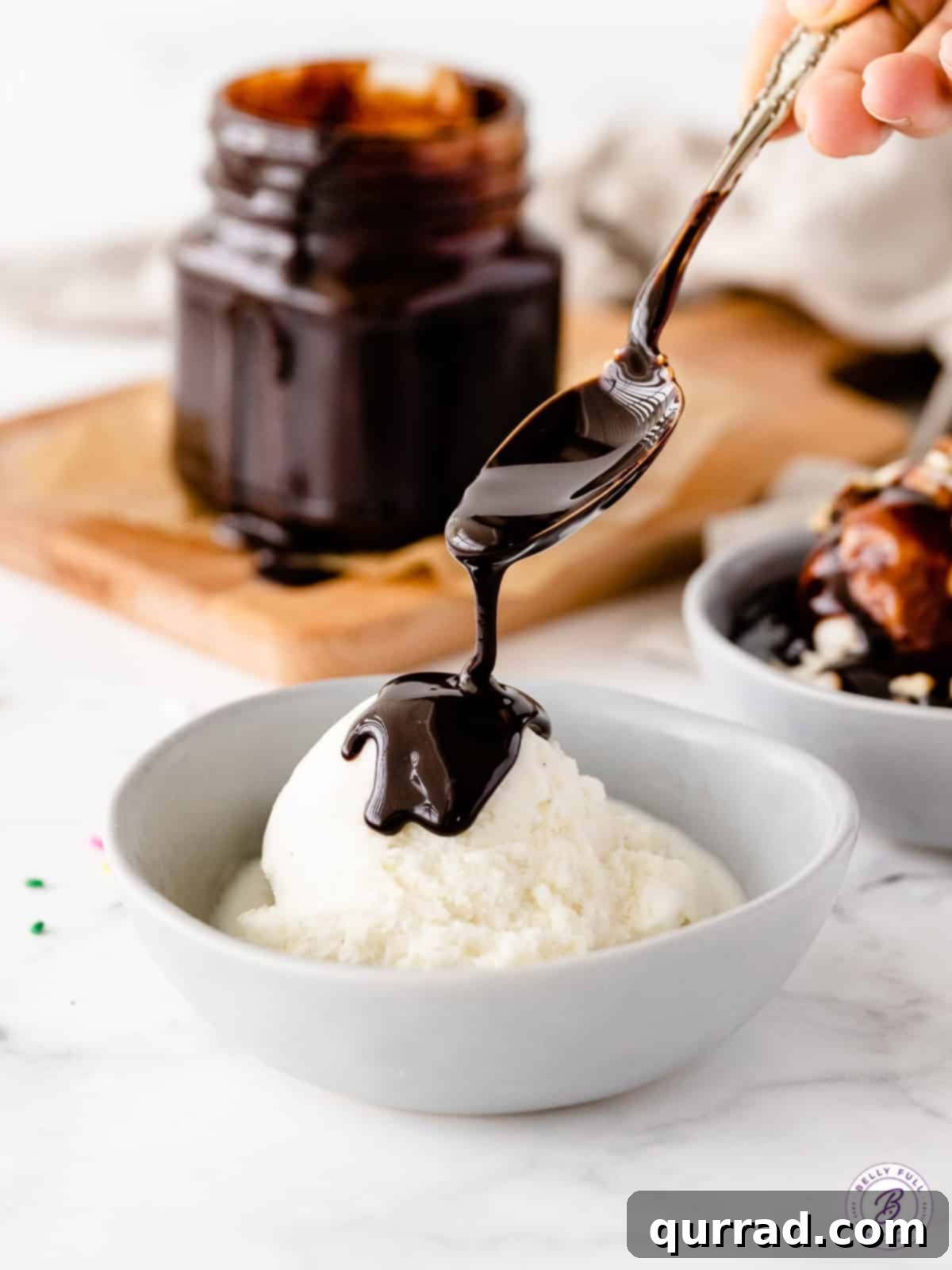 Rich Homemade Chocolate Sauce 3 Homemade chocolate sauce being spooned generously over vanilla ice cream