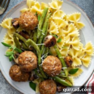 close up overhead picture of cooked turkey meatballs, green beans, mushrooms, and bowtie pasta on white plate