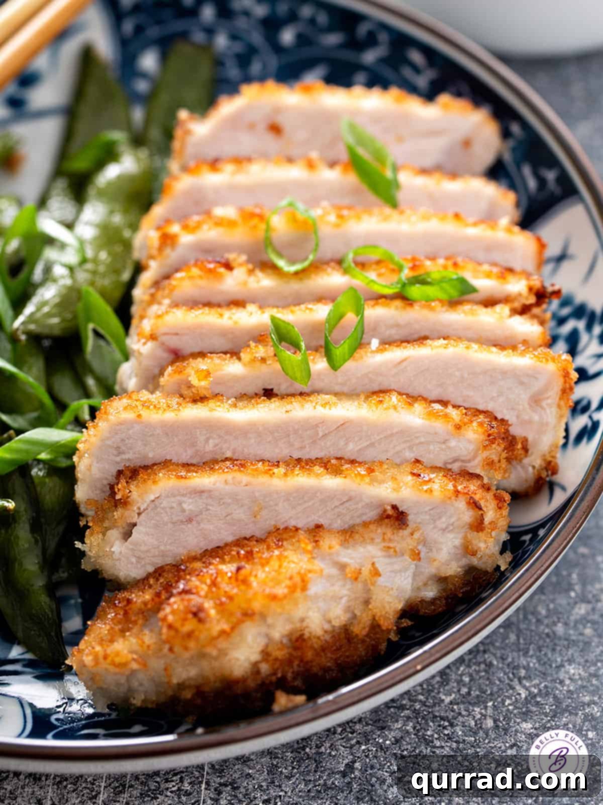 Crispy Pork Cutlet Delights 5 sliced panko-crusted pork chop on plate with green vegetables