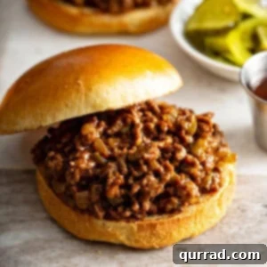 Close up view of easy homemade sloppy joes, showing the saucy meat and a toasted bun