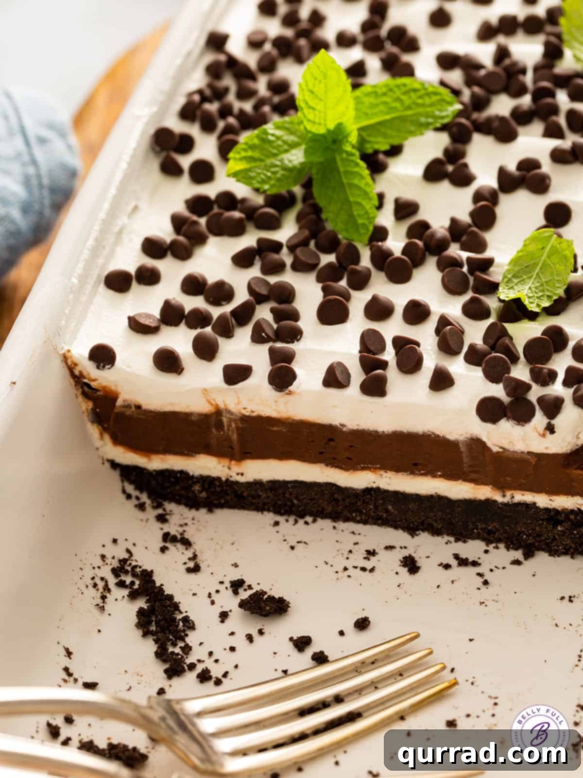 A delicious Chocolate Lasagna, or Oreo Lush, in a casserole dish with a generous portion already served, showing off its perfectly set layers.