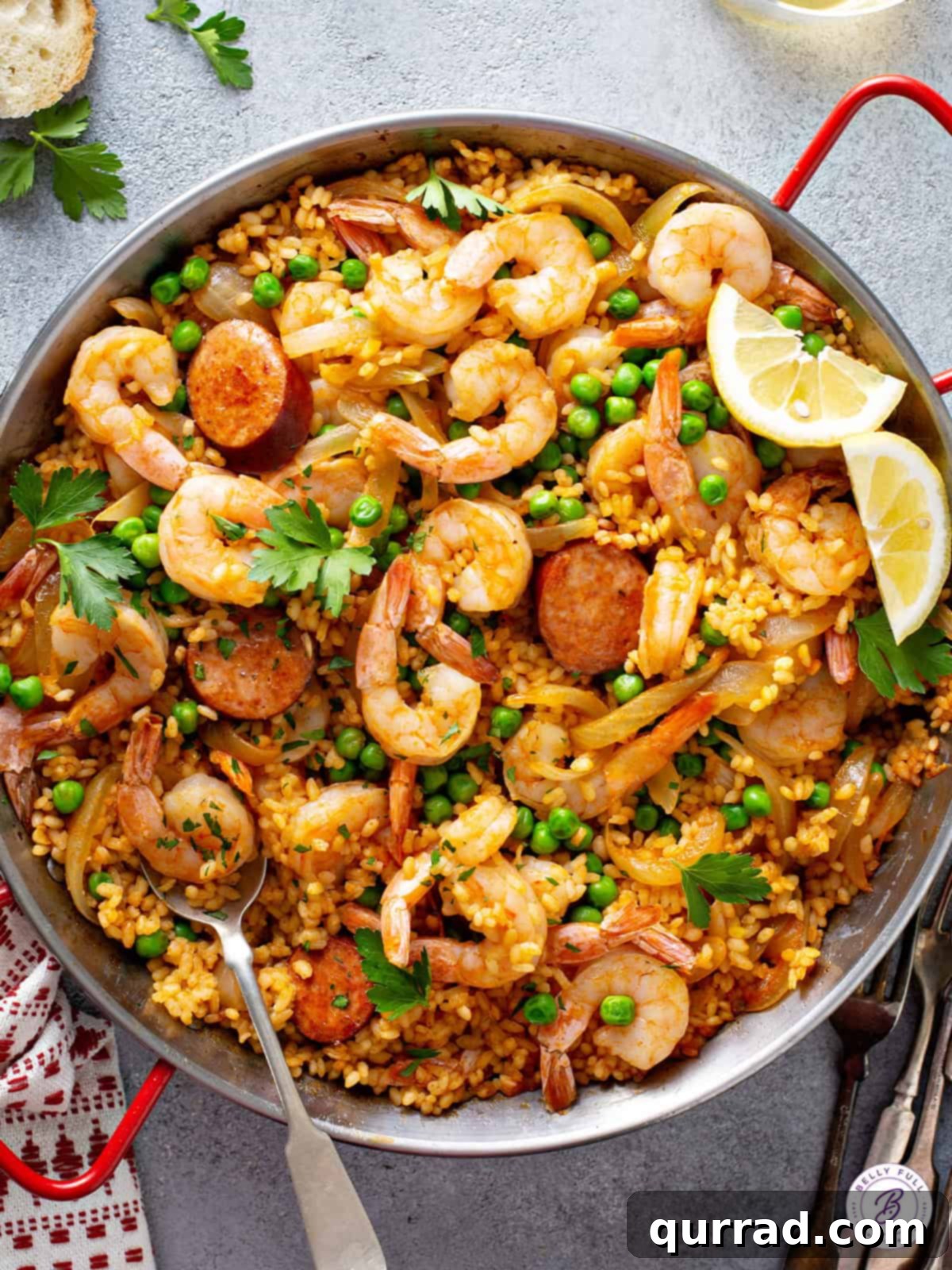 Simplified Weeknight Paella 2 Vibrant Spanish Paella with succulent shrimp and smoky chorizo in a traditional paella pan, garnished with fresh herbs and lemon wedges, ready to be served.