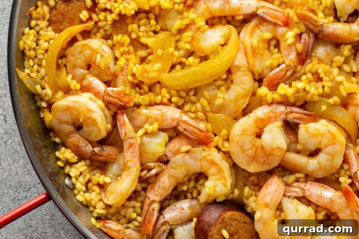 Simplified Weeknight Paella 7 Low sodium chicken stock being carefully poured over the evenly spread rice and chorizo mixture in the paella pan, ready to commence simmering.