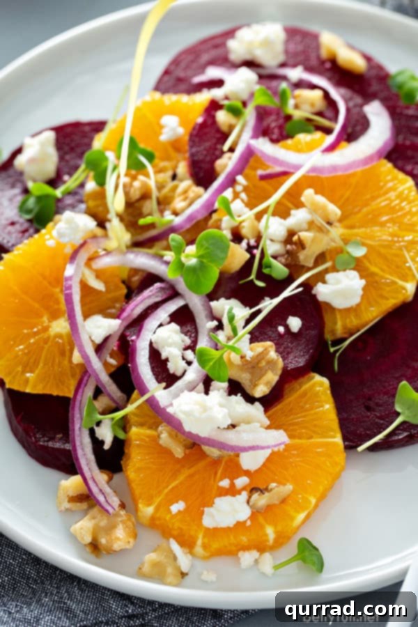 Bright and delicious orange beet salad on a white plate, garnished with fresh herbs and crumbled feta cheese