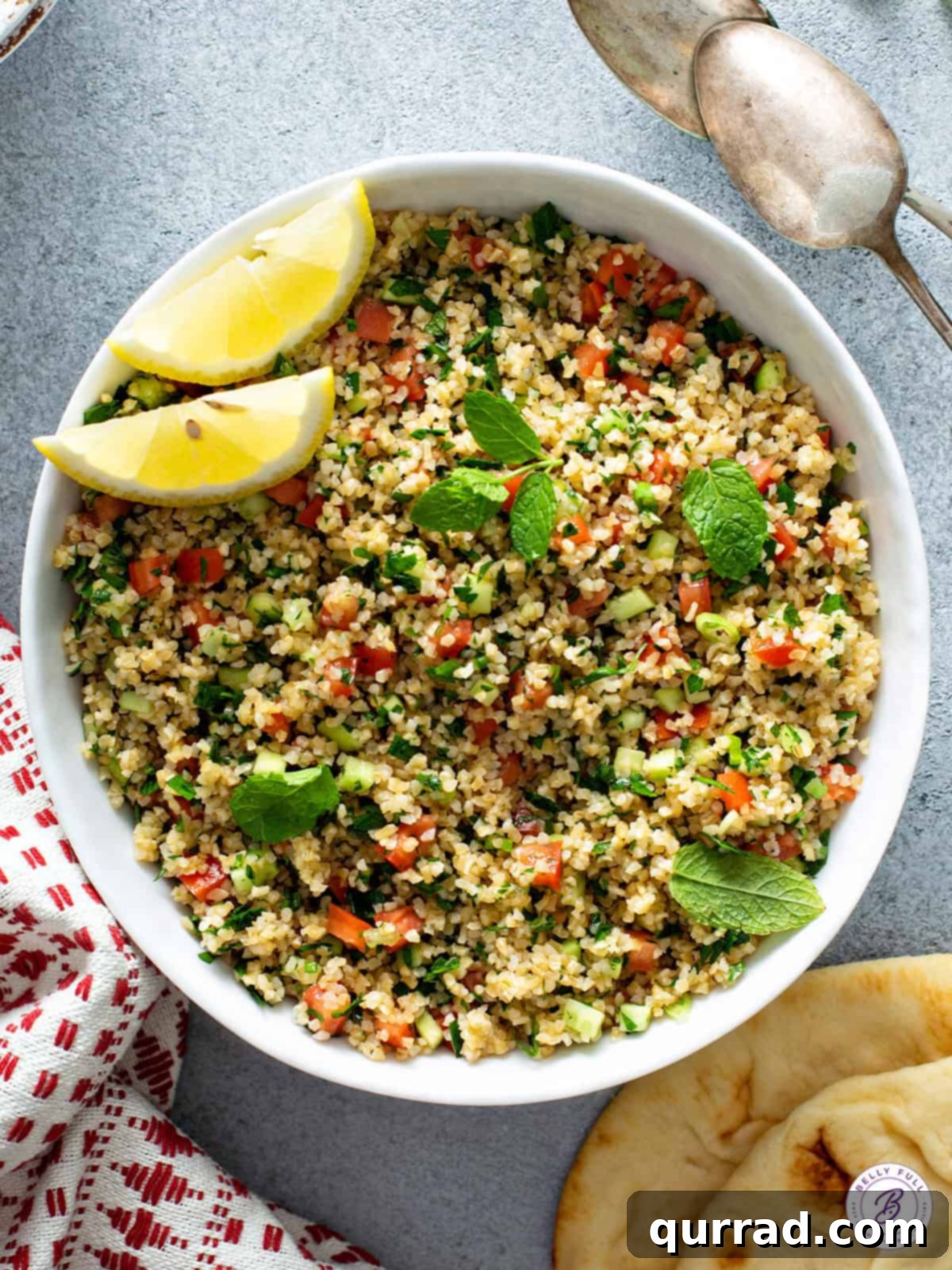 Overhead bowl of Tabbouleh with lemon wedges.