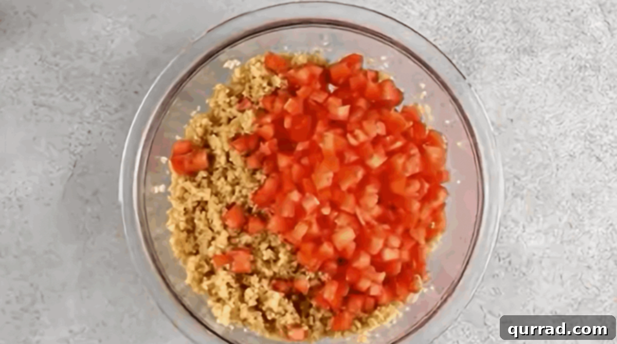Adding chopped tomatoes to the soaked bulgur.