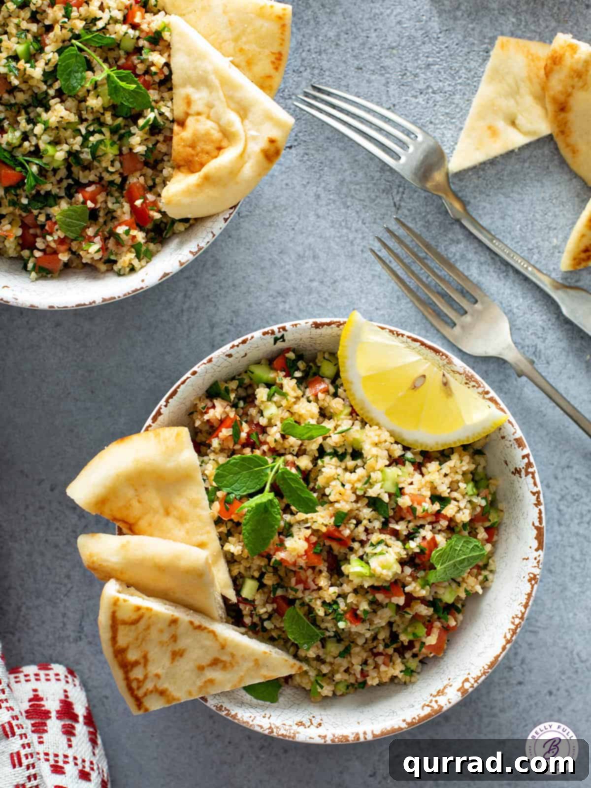 Tabbouleh salad in bowl with lemon wedge and naan.