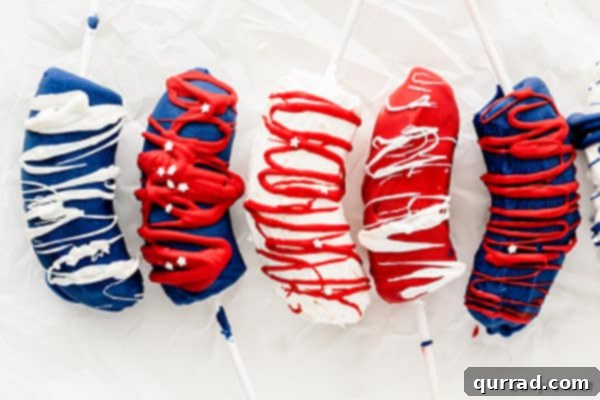 5 frozen bananas on a stick coated in red, white, and blue chocolate