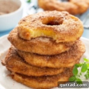 stack of 5 pineapple fritter rings with bite taken from top one