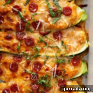 close up of 5 baked zucchini halves stuffed pizza toppings