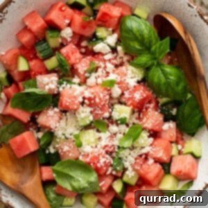 Cooling Watermelon Feta Salad 3 Overhead of watermelon salad in ornate serving bowl with wooden serving utensils