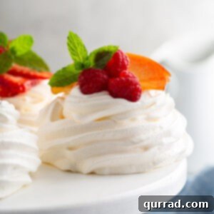 Perfect Mini Pavlova Bites 6 mini pavlova with fresh raspberries on white cake stand