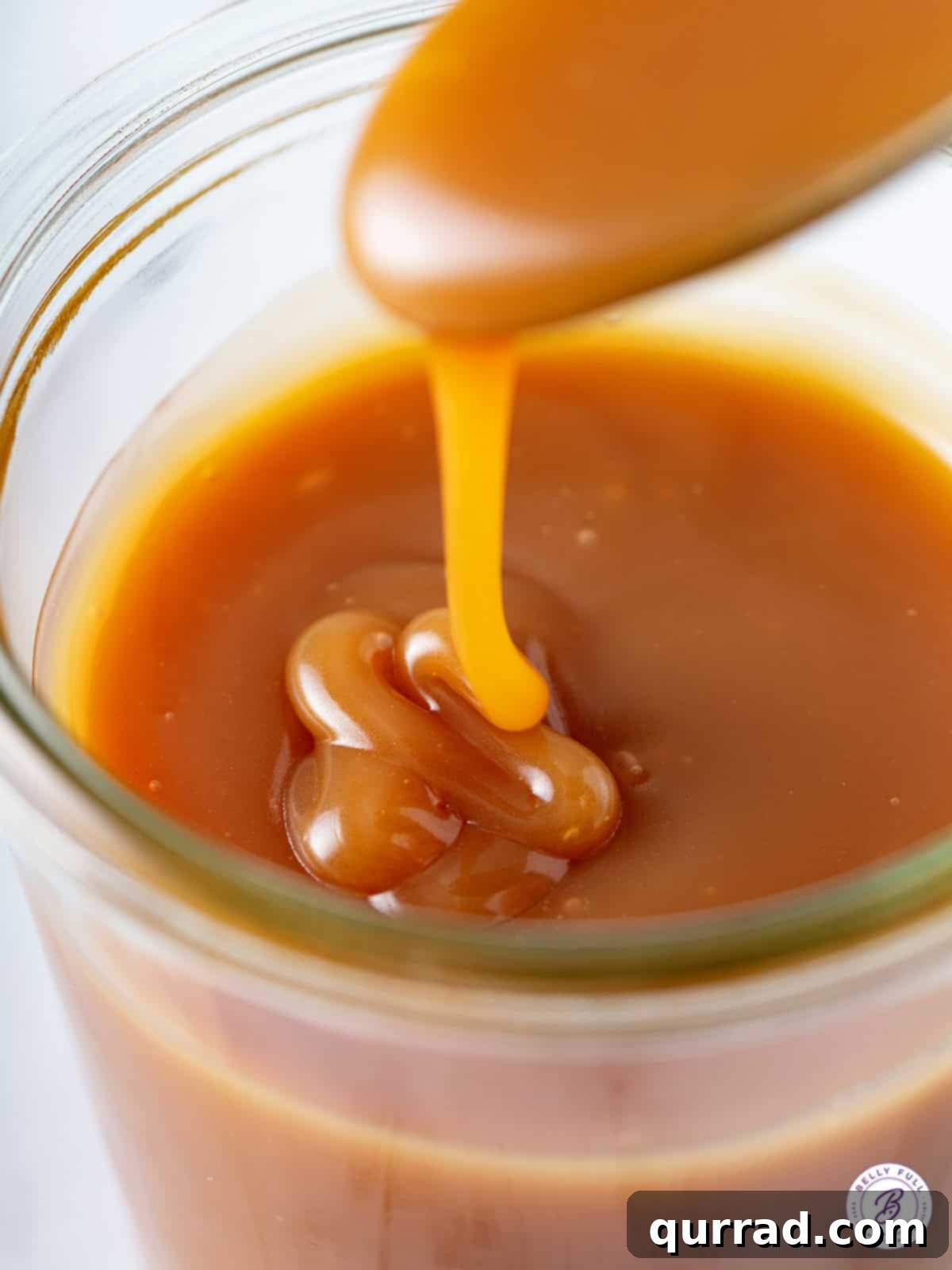 Golden Caramel Delight 5 Close-up of gooey caramel sauce on a spoon, highlighting its luscious texture and rich color.