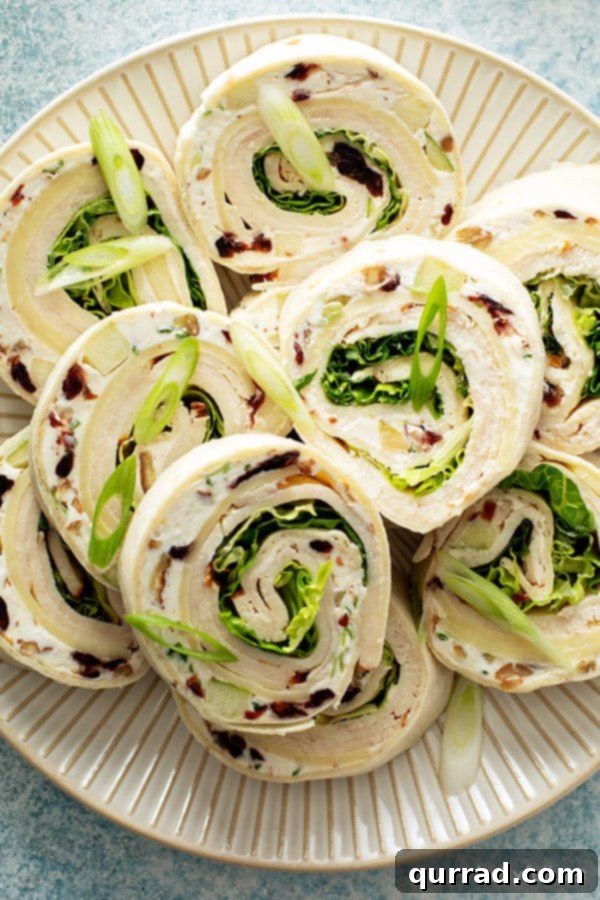 Spiral Chicken Salad Bites 11 Chicken salad pinwheels appetizers stacked neatly on a plate, ready to serve.